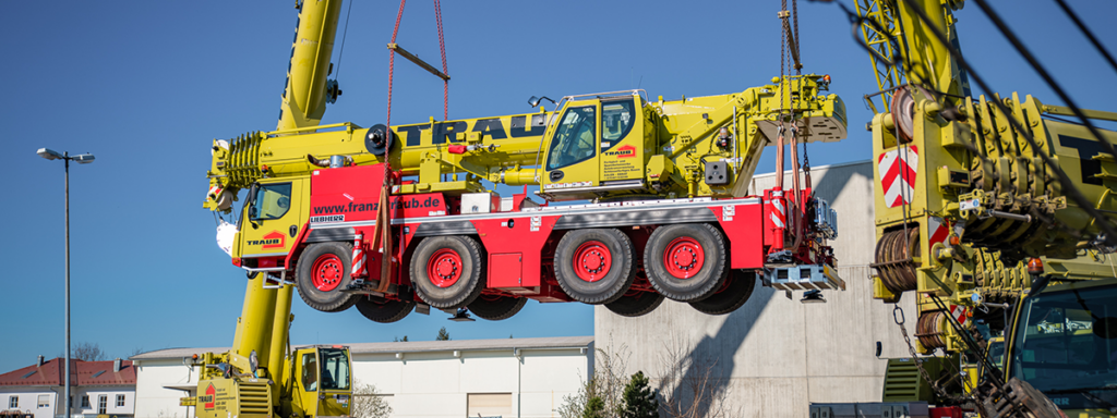 Franz Traub Kran hebt Baustellenfahrzeug in die Höhe