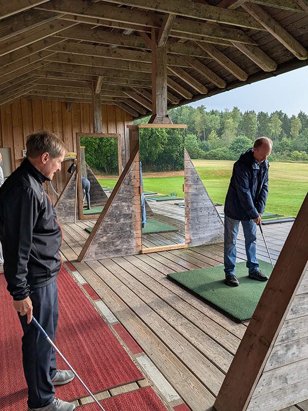 Übung Abschlag eines Teilnehmers zusammen mit Golflehrer