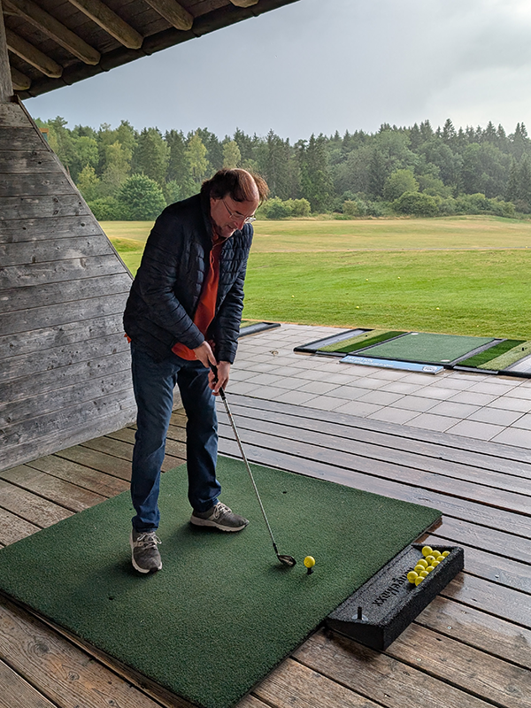 Übung Abschlag eines Teilnehmers innerhalb eines Metallrings. Zusammen mit Golflehrer