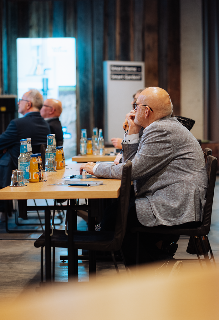 sitzender Teilnehmer lauscht Vortrag
