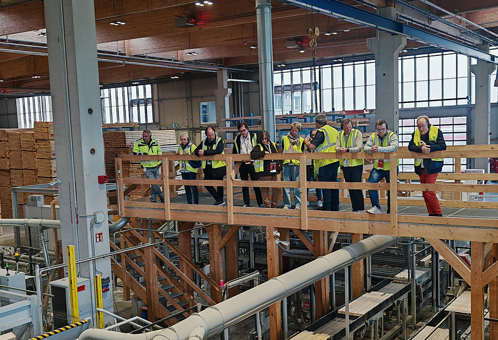 Teilnehmer bei der Besichtigung der Ladenburger Holzwerke stehen auf einer Holzbrücke in der Produktionshalle