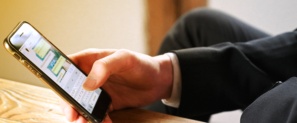 Unterarm und Hand eines Mannes, der Textnachricht in WhatsApp erstellt